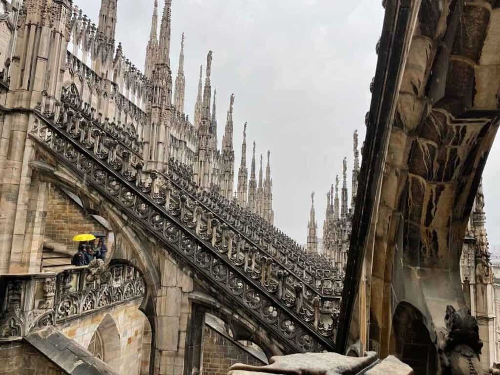 The Duomo Milan roof terrace with its spires, arches and statues is an impressive site in the center of Milan.