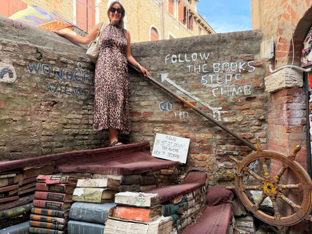 Italy Itineraries, City Guides, Travel Tips 5 Christina from italythingstodo standing on the book stair in Venice